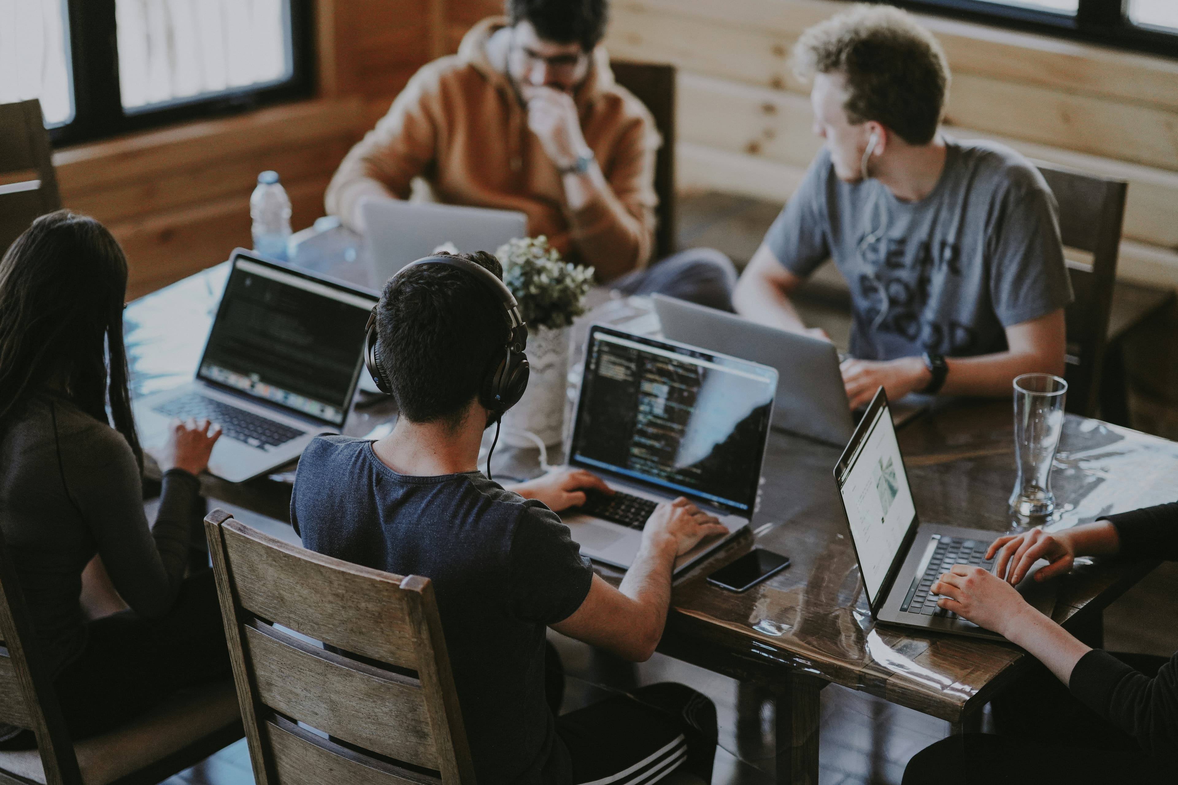 Equipo de tecnología colaborando alrededor de una mesa